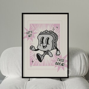 Può includere: Un'illustrazione in bianco e nero di un panino di cartone animato con un viso sorridente, che corre con il testo "Let's Get This Bread" in uno stile di fumetto rosa e bianco.