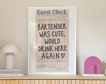 Op de afbeelding: Een ingelijst afdruk van een vintage gastenbon met de handgeschreven boodschap "Bartender was cute, would drink here again". De bon is gedateerd 051197.