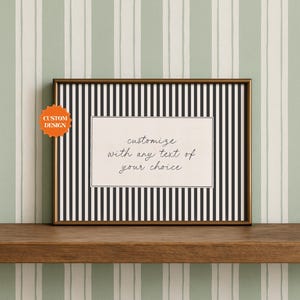 May include: A rectangular picture frame with a thin bronze border containing a black and white vertical striped background. A white rectangular insert features the black cursive text: customize with any text of your choice.