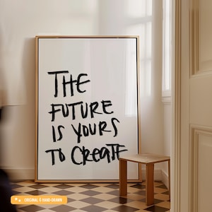May include: A framed art print with the text "THE FUTURE IS YOURS TO CREATE" in black brushstrokes. The artwork is displayed in a room with a small wooden stool and a checkered floor.