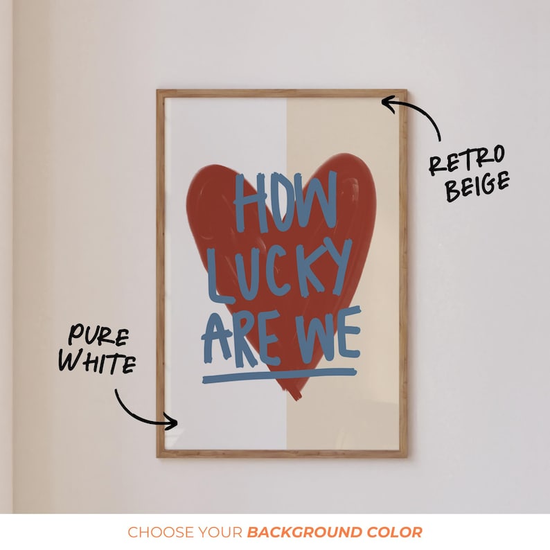 May include: A framed art print featuring a large red heart with the words "HOW LUCKY ARE WE" in blue. The background is split between pure white and retro beige. The print is in a wooden frame.