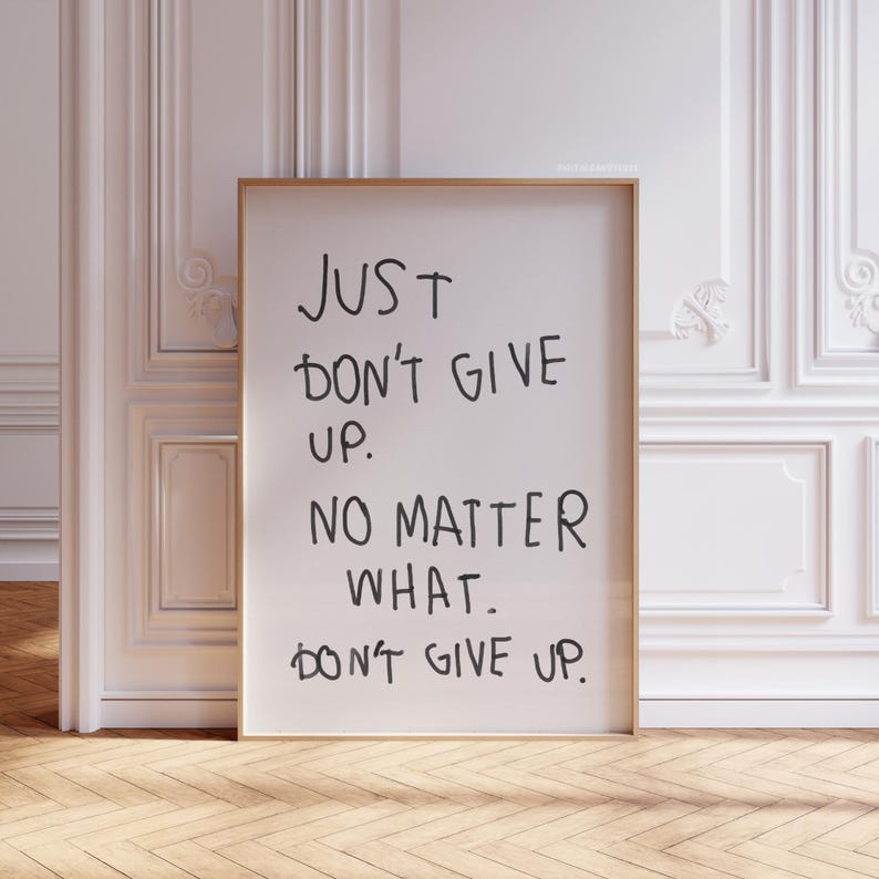May include: A white framed poster with black handwritten text that reads "JUST DON'T GIVE UP. NO MATTER WHAT. DON'T GIVE UP."