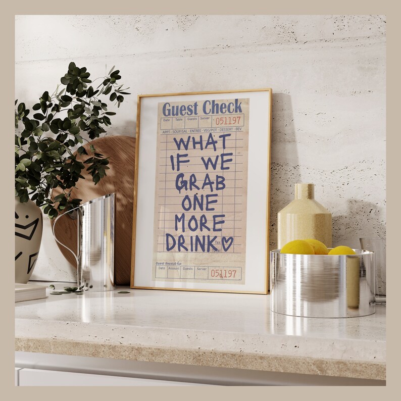 May include: A framed print of a guest check with the text "What if we grab one more drink" written in blue ink on a white background. The check has a date of 051197.