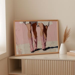 May include: A painting of two pairs of legs wearing pink cowboy boots against a light pink background.