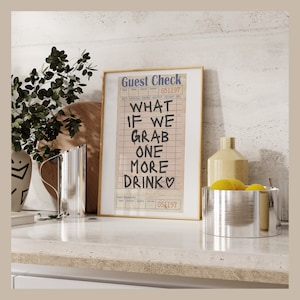 May include: A framed print of a guest check with the text "What if we grab one more drink" written on it. The check is dated 05/11/97.