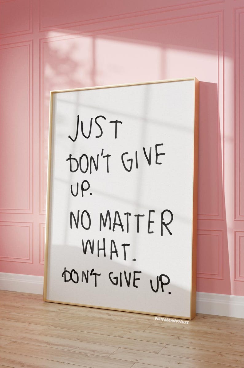May include: A white framed poster with black handwritten text that reads "JUST DON'T GIVE UP. NO MATTER WHAT. DON'T GIVE UP."