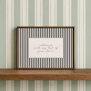 May include: A framed print with a gold-colored frame. The print features a black and white striped pattern with a white rectangle in the center. The text "customize with any text of your choice" is written in cursive.