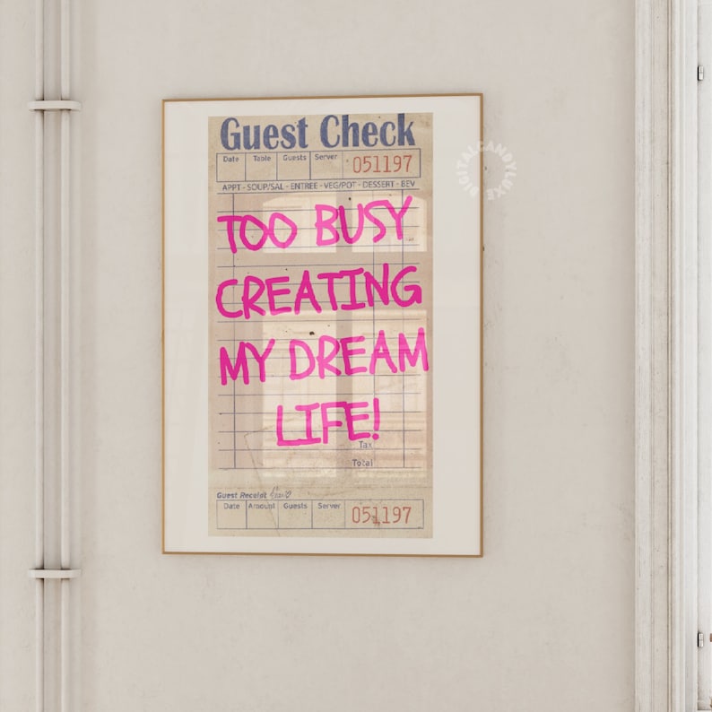 May include: A vintage-style guest check with the text "TOO BUSY CREATING MY DREAM LIFE!" written in pink marker.