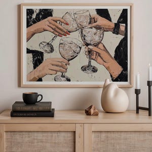 May include: A framed painting of four hands holding up glasses of wine, with a white background and black accents. The painting is hanging on a wall above a wooden shelf with books and decorative objects.