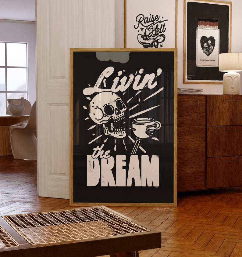 May include: Black framed art print with a skull and coffee cup graphic, the words "Livin' the Dream" in white. Additional framed art pieces are visible in the background, including one with the text "Raise Hell".