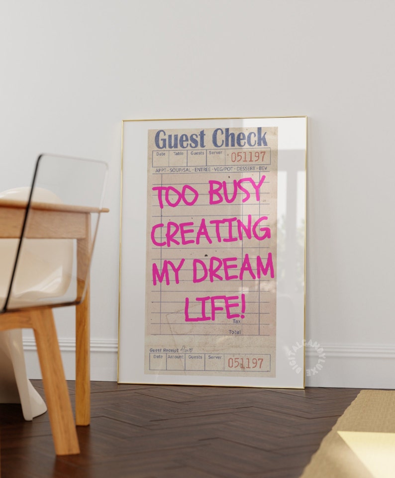 May include: A framed print with a vintage guest check design. The text "Too Busy Creating My Dream Life!" is written in pink on the check. The check has a date of 051197.