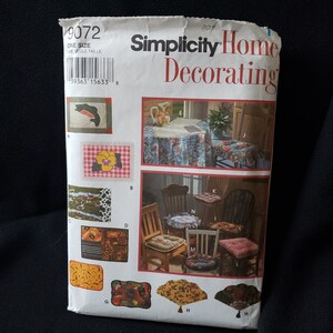 May include: A Simplicity Home Decorating pattern envelope featuring various home decor projects. The cover displays images of placemats, chair cushions, and a tablecloth. The pattern number is 9072, and the size is one size.