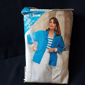 May include: A vintage sewing pattern envelope with a woman wearing a blue jacket and white pants. The pattern number is 5408 and the size is 8-10-12. The text "McCall's" is visible on the envelope.
