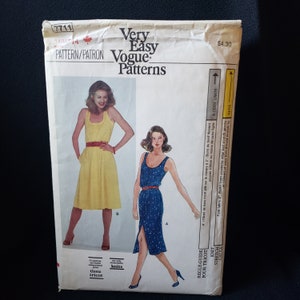 May include: A vintage Vogue Patterns sewing pattern envelope. The envelope features illustrations of two dresses, one yellow and one blue, with a red belt. The text "Very Easy Vogue Patterns" is visible.