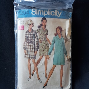 May include: A sewing pattern for three dresses, Simplicity pattern number 8294. The pattern includes a plaid dress, a floral print dress, and a solid blue dress. The pattern is for misses sizes 14-36.