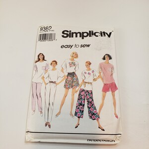 May include: Simplicity sewing pattern number 8362 for easy to sew tops and trousers. The pattern includes five different styles of tops and trousers, including a striped top and trousers, a white top and trousers, a floral top and shorts, a floral top and trousers, and a pink top and shorts.