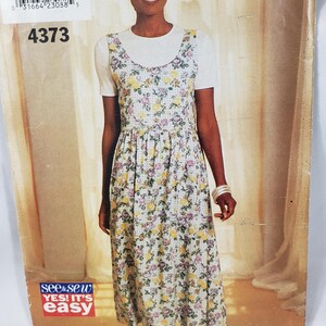 May include: A vintage See & Sew sewing pattern, number 4373, showing a woman in a floral dress with a white top. The pattern includes sizes A/XS-S-M. The packaging has the text "YES! IT'S EASY".