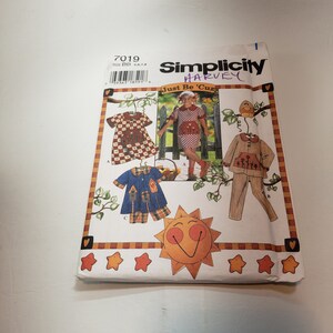 May include: Simplicity pattern 7019 for children's clothing. The pattern includes three designs: a dress, a shirt and shorts, and a pajama set. The pattern is titled "Just Be 'Cuz" and features a sun with a smiley face and stars.