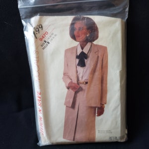 May include: A vintage McCall's sewing pattern for a suit, featuring a beige blazer and skirt. The pattern number is 9470 and the size is B (14-16-18).