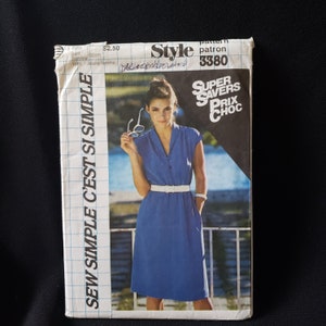 May include: A vintage sewing pattern titled "Style 3380" featuring a woman in a blue dress with a white belt. The pattern cover includes the text "Sew Simple C'est Si Simple" and "Super Savers Prix Choc". The bust size is 32 inches.