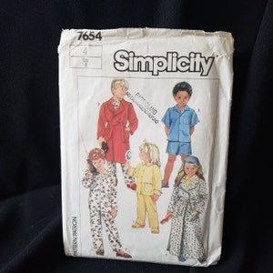 Op de afbeelding: Simplicity naaipatroon nummer 7654 voor kinderpyjama's en badjassen. Het patroon bevat vier verschillende ontwerpen: een rode badjas, een blauwe pyjamaset, een gele pyjamaset en een bloemenbadjas. Het patroon is gedrukt op een witte achtergrond met zwarte tekst.