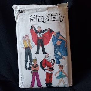 May include: Simplicity sewing pattern number 7651 for small, petite, and medium sizes. The pattern includes five different costumes: a pirate, a vampire, a belly dancer, Santa Claus, and a ballerina. The pattern is printed on a white background with red and black text.