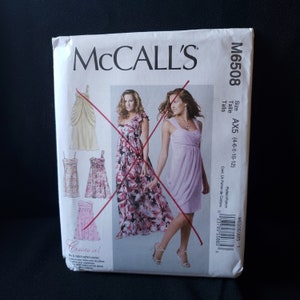 May include: A McCall's sewing pattern envelope, model M6508, featuring illustrations of various dress designs. The envelope includes the size range AX5 (4-6-8-10-12). The text "Create it!" is also visible.