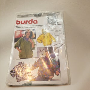 May include: A Burda sewing pattern package for a ski shirt. The pattern includes three different styles, one for a woman and two for men. The pattern number is 4416. The package is white with a blue and red logo.