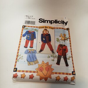 May include: Simplicity sewing pattern 7277 for children's clothing. The pattern includes three different designs: a red and black plaid shirt with pants, a blue and black plaid shirt with pants, and a blue and white shirt with shorts. The pattern is titled "Just Be 'Cuz" and is by Donna Malone & Kenna folds.