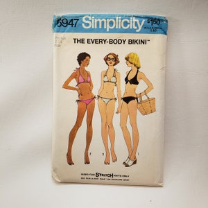 May include: Simplicity sewing pattern number 5947 for a bikini. The pattern is for stretch knits only. The pattern shows three women wearing different styles of bikinis. The text on the pattern reads "The Every-Body Bikini".