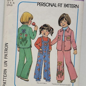 Puede incluir: Patrón de costura Simplicity número 7815 para ropa de niños. El patrón incluye dos tallas, 3 y 4, y es un patrón "Personal-Fit". El patrón muestra a tres niños con diferentes atuendos, incluyendo una chaqueta y pantalones verdes, un vestido de peto azul y una chaqueta y pantalones rosas. El patrón incluye una transferencia para aplique.