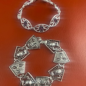 2 Vintage 1970’s Sara Coventry bracelets. A Crab and Tribal face silver tone bracelet. A silver tone amethyst cut glass link bracelet.