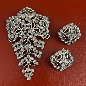 Vintage Monet 1960’s articulated silver plate brooch and matching clip on earrings. Signed.