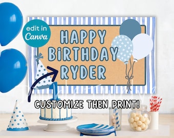 May include: A birthday banner with the text "HAPPY BIRTHDAY RYDER" in blue. The banner has a striped background and is decorated with balloons. A cake, party hats, and other party supplies are also visible.