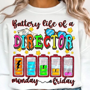 May include: White sweatshirt with a colourful graphic that says "Battery life of a DIRECTOR" with five battery icons labelled "monday" and "friday".