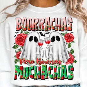 May include: White sweatshirt with a graphic featuring two ghost figures toasting wine glasses. The text "BOORRACHAS Pero Buenas MUCHACHAS" is displayed in a colorful, floral design, with red roses and bats.
