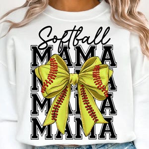 May include: White sweatshirt with the words "Softball Mama" in black script and block letters. A large yellow bow with red stitching, resembling a softball, is the central design element.
