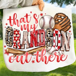 May include: White baseball-themed blanket with the text "that's my GRANDSON out there" in red and leopard print lettering. Includes baseballs, a glove, and bats. A perfect gift for baseball fans.