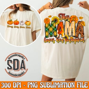 May include: A sublimation design featuring a white t-shirt with a graphic of the text "This Mama loves her pumpkin" with a plaid, leopard print, and sunflower design. The text "Henry, Emily, Emma, Anna" is printed on the front of the shirt.