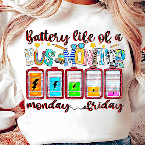 May include: White sweatshirt with the text "Battery life of a Bus Monitor" in colorful letters. The text is surrounded by colorful battery icons and the words "monday" and "friday" are below the batteries.