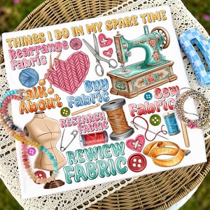 May include: A white square graphic with the text "THINGS I DO IN MY SPARE TIME" and illustrations of sewing and crafting items. Includes a sewing machine, yarn, fabric, buttons, and a dress form. The graphic is on a wicker basket.