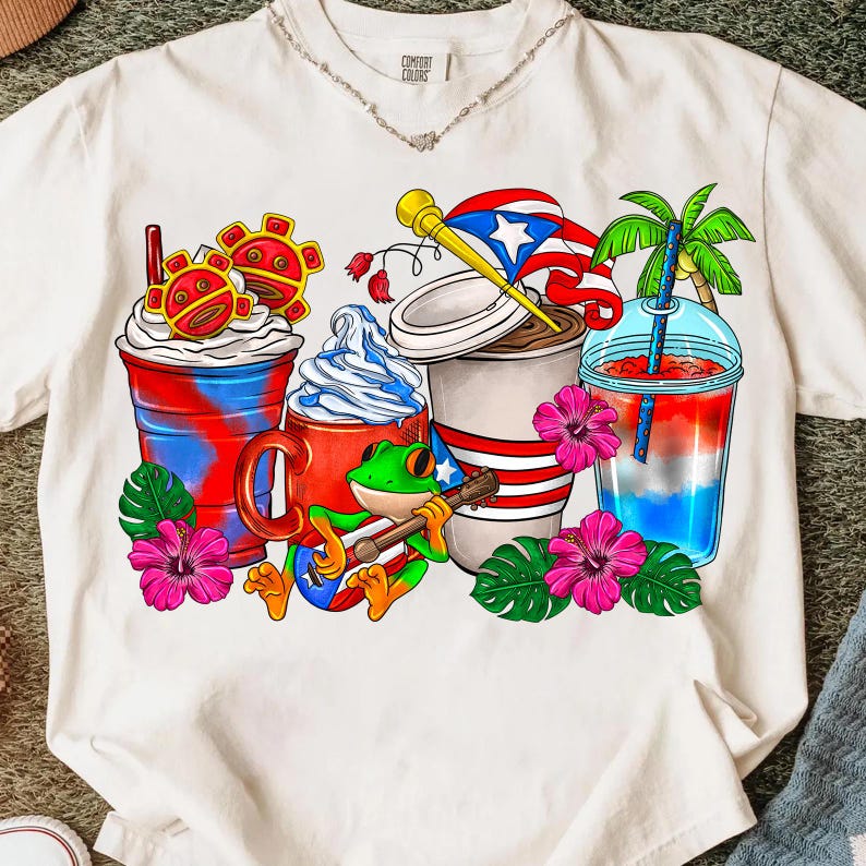 May include: White t-shirt featuring a colorful graphic of various beverages, including a coffee cup with a flag, a red mug, and a layered drink. A frog playing a guitar is in the center. Tropical flowers and palm leaves are also included.