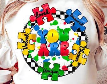 May include: White sweatshirt with a colorful puzzle piece design that says "You Are" in the center. The puzzle pieces have the words "Loved", "Valued", "Treasured", "Chosen", and "Unique" on them.