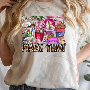 May include: A white t-shirt with the text "I can totally MAKE THAT" in black and brown lettering. The text is surrounded by a variety of colorful illustrations, including coffee cups, paintbrushes, and other craft supplies.