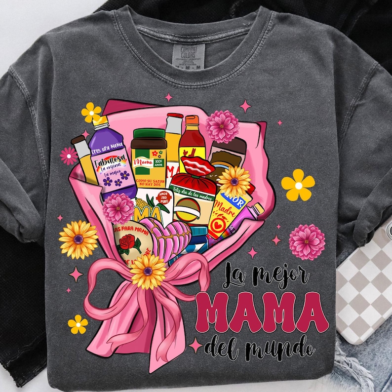 May include: A gray t-shirt with a pink bouquet of flowers and various Mexican food and drink items. The text "La mejor MAMA del mundo" is printed on the shirt.