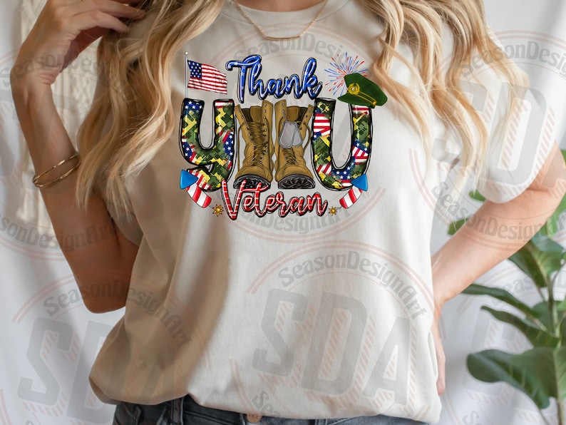 May include: White t-shirt with a graphic design that says "Thank You Veteran" with a camouflage pattern, an American flag, boots, and fireworks.