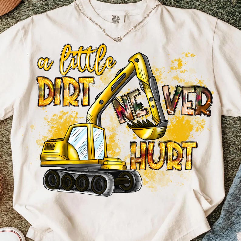 May include: White t-shirt with a yellow excavator graphic and the text "a little dirt never hurt" in a playful font. The excavator is detailed with black and gray accents, and the text has a watercolor effect.