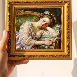 May include: A square oil painting in a decorative gold frame depicting a person with closed eyes resting on a green upholstered sofa. The person wears a light pink garment with white lace sleeves and floral hair accessories. The text ZADONS is visible.