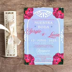 Op de afbeelding: Een huwelijksuitnodiging met een blauwe achtergrond en roze rozen. De uitnodiging luidt "Te invitamos cordialmente a Nuestra Boda Sergio -y- Lucia 12 Junio 2025 Sabado, a las 4:00 PM Cualquiera Calle 678, Cualquier Lugar, CP 7590. Recepcion a las 6:00 PM Cualquiera Calle 678, Cualquier Lugar, CP 7890 Cena: 7:00PM-8:00PM Baile: 8:00PM-12:00AM"