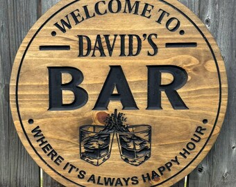 May include: A round wooden sign with the words "WELCOME TO DAVID'S BAR" in a circular design. The sign also features the text "WHERE IT'S ALWAYS HAPPY HOUR" and an illustration of two cocktail glasses.